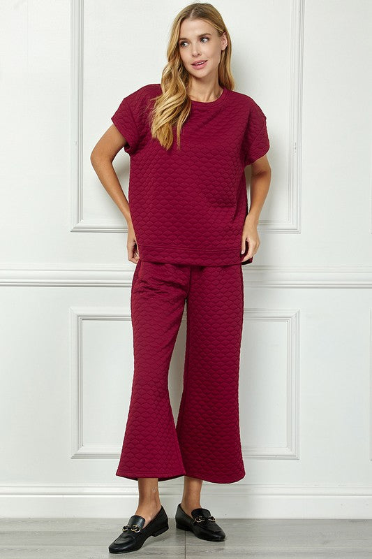 Honey Comb Textured Set: maroon short-sleeve top with chest pocket and flared pants. Available in sizes XS–XL.