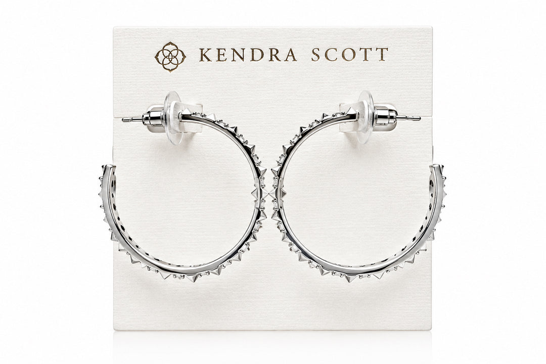 Fate Hoop Rhodium White Cz earrings feature sculptural spike hoops with white cubic zirconia, offering an edgy design. Available in small and medium sizes.