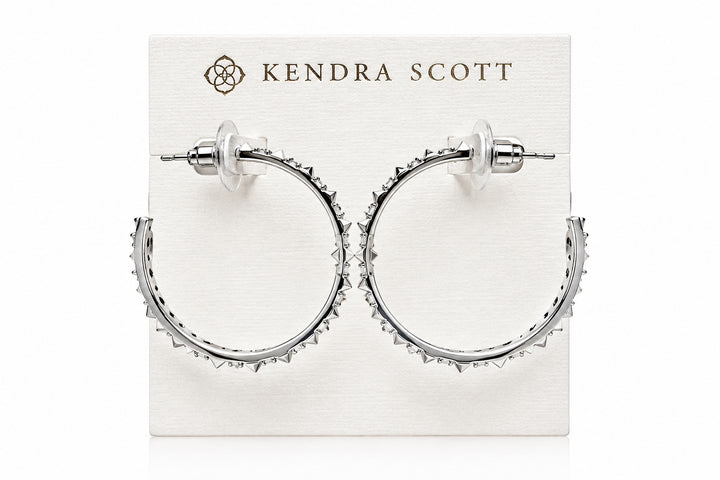Fate Hoop Rhodium White Cz earrings feature sculptural spike hoops with white cubic zirconia, offering an edgy design. Available in small and medium sizes.