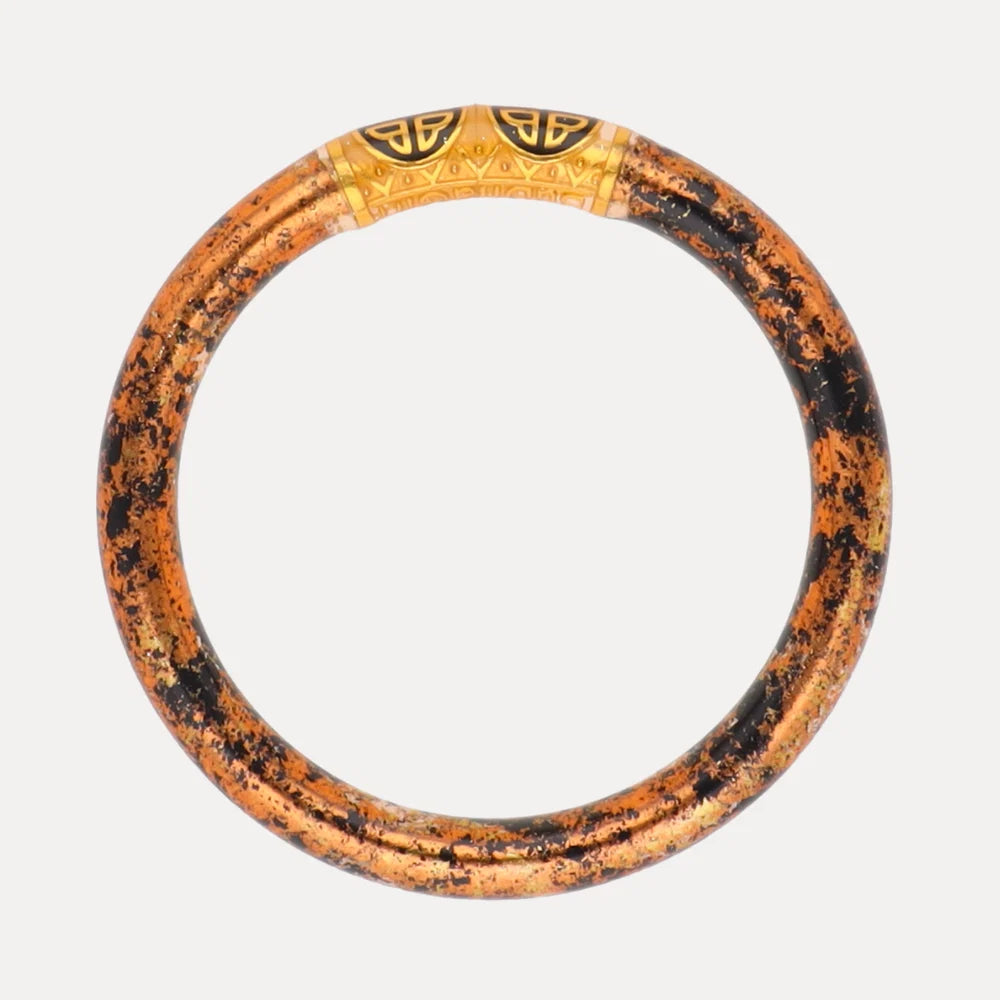 Round, stackable bangle bracelet with a speckled orange and black pattern and a gold engraved segment at the top. Available in multiple sizes.