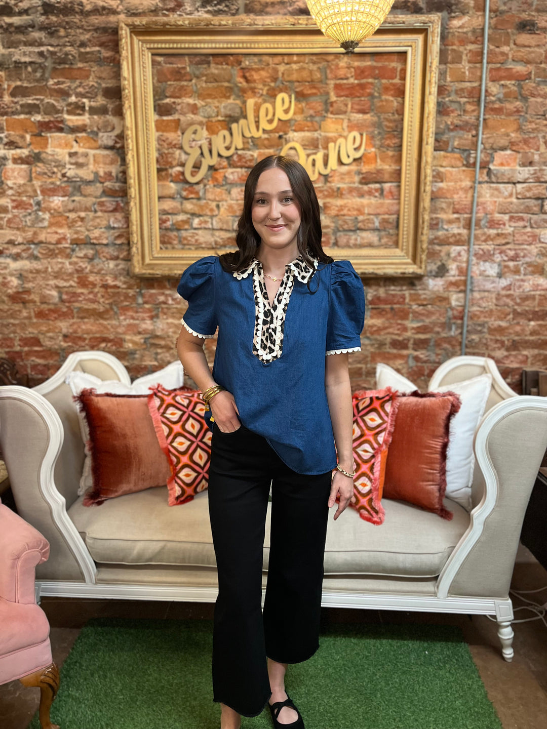 Blue denim short-sleeved blouse with leopard print placket and scalloped collar and sleeve trim.