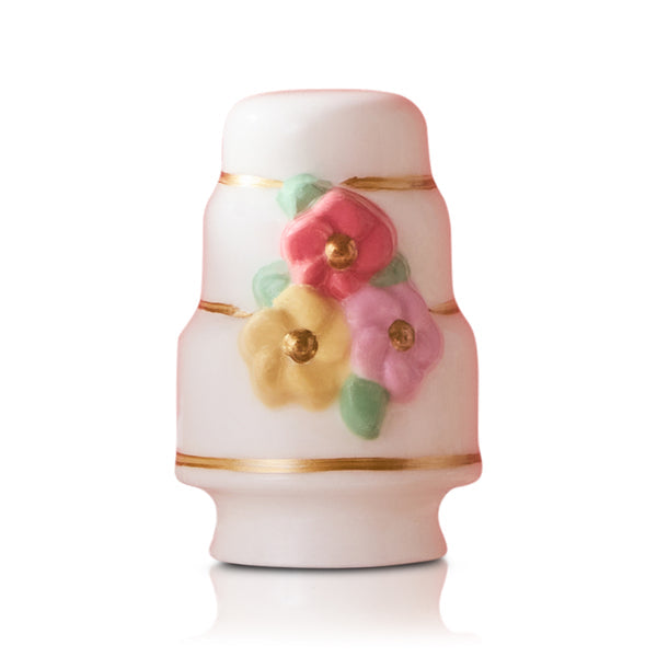 White porcelain Nora Fleming Minis shaker with gold bands and raised pink/yellow flowers. Sizes available: not specified.