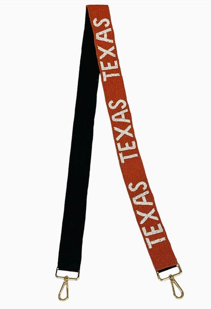Beaded Texas Bag Strap with one side solid black, the other burnt orange, “TEXAS” in white repeated throughout, and gold hooks at both ends. Sizes available: not specified.