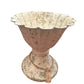 Rustic weathered bowl-shaped White Urn Metal on pedestal base with fluted top. Worn finish, twine string with tassel. Resembles antique white urn in concrete/stone appearance. Available sizes: Small, Medium, Large.