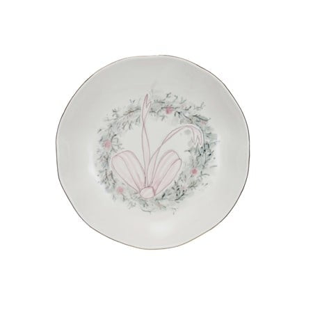Round stoneware bowl with gold-rimmed edge, wreath motif, and pink bow.