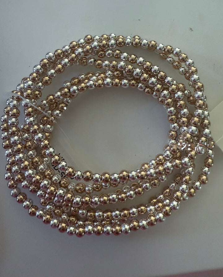 Gold and silver beaded stretch bracelet in a circular pattern. Available sizes: small, medium, large.