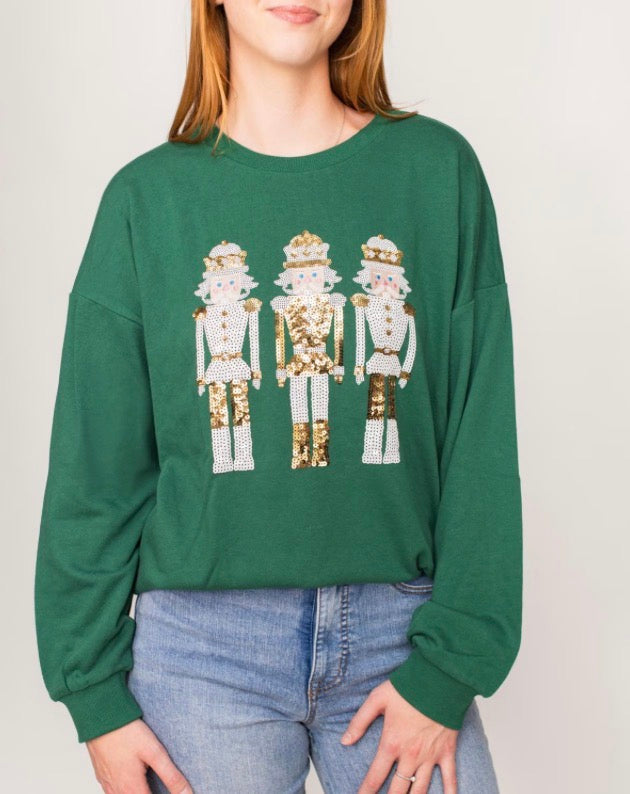 Alpine Nutcracker Sequin Sweatshirt: dark green with gold and white sequin nutcrackers; available in sizes XS–XL.
