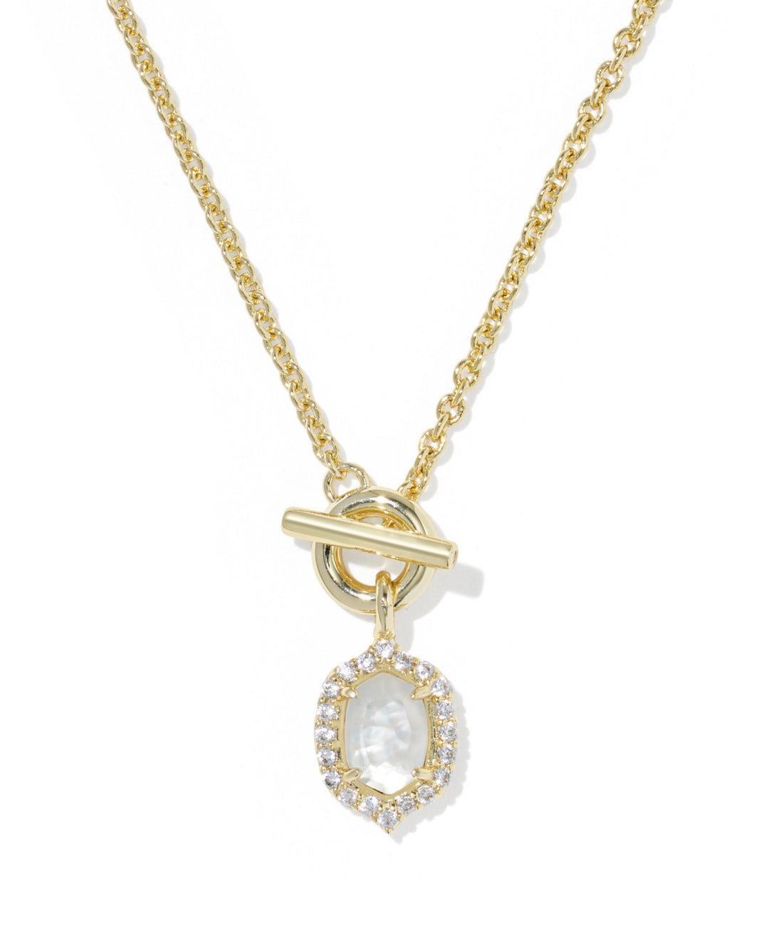 The Daphne Crystal Frame Toggle Necklace in Gold Mother of Pearl features an oval pendant with a clear gemstone, framed by crystals, and finished with a toggle clasp. Available sizes: 16″, 18″.
