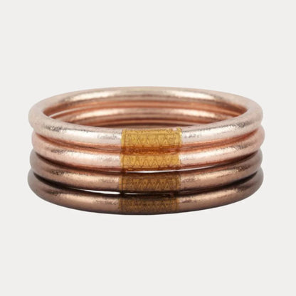 Four metallic BuDhaGirl Fawn All Weather Bangles® in copper tone with Serenity Prayer. Available in small, medium, large.