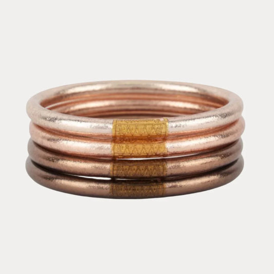 Four metallic BuDhaGirl Fawn All Weather Bangles® in copper tone with Serenity Prayer. Available in small, medium, large.