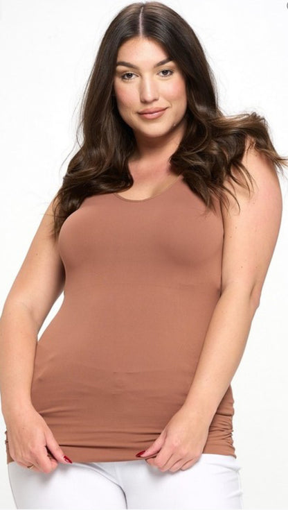 A woman with long, dark brown hair wearing a Reversible V or U Neckline Seamless Tank in brown with sizing details and white pants.
