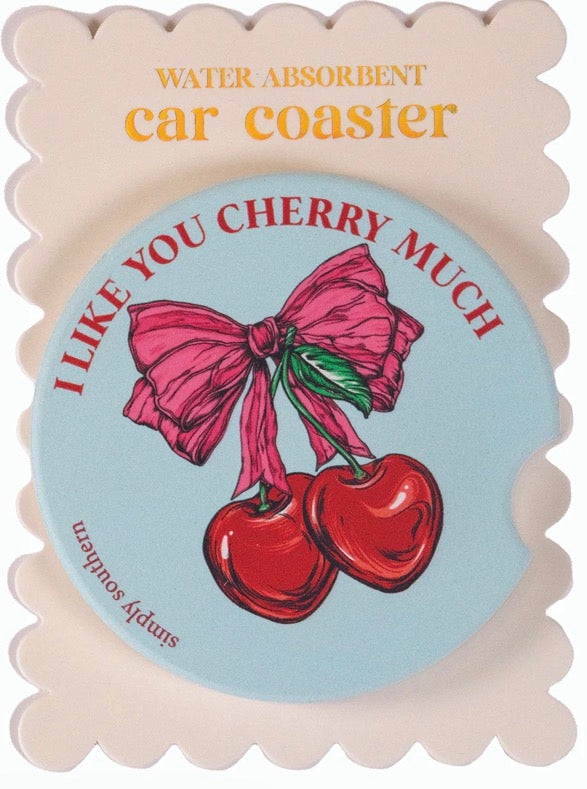 Round light blue car coaster with two red cherries, pink bow, "I LIKE YOU CHERRY MUCH." Water-absorbent. Fits standard holders.
