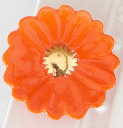 Orange, flower-shaped Nora Fleming Mini with scalloped edges and gold center. Available sizes: mini only.