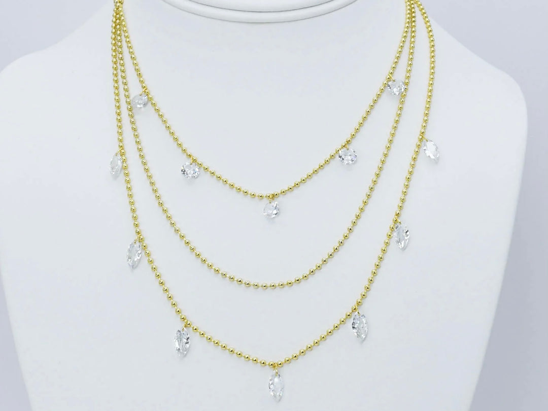 Three gold beaded chains with clear teardrop crystal pendants. Available in 16", 18", and 20" lengths.
