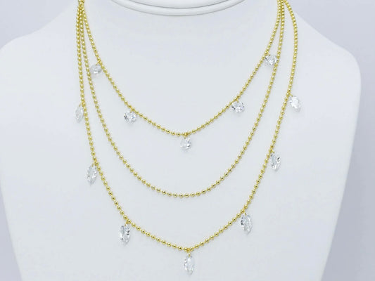 Three gold beaded chains with clear teardrop crystal pendants. Available in 16", 18", and 20" lengths.