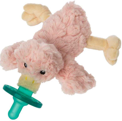A pink plush toy resembling a stylized lamb with a green WubbaNub Pacifier attached, positioned sideways against a white background.