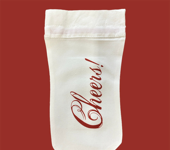 Off-white fabric Holiday Wine Bottle Bag with red “Cheers!” script.