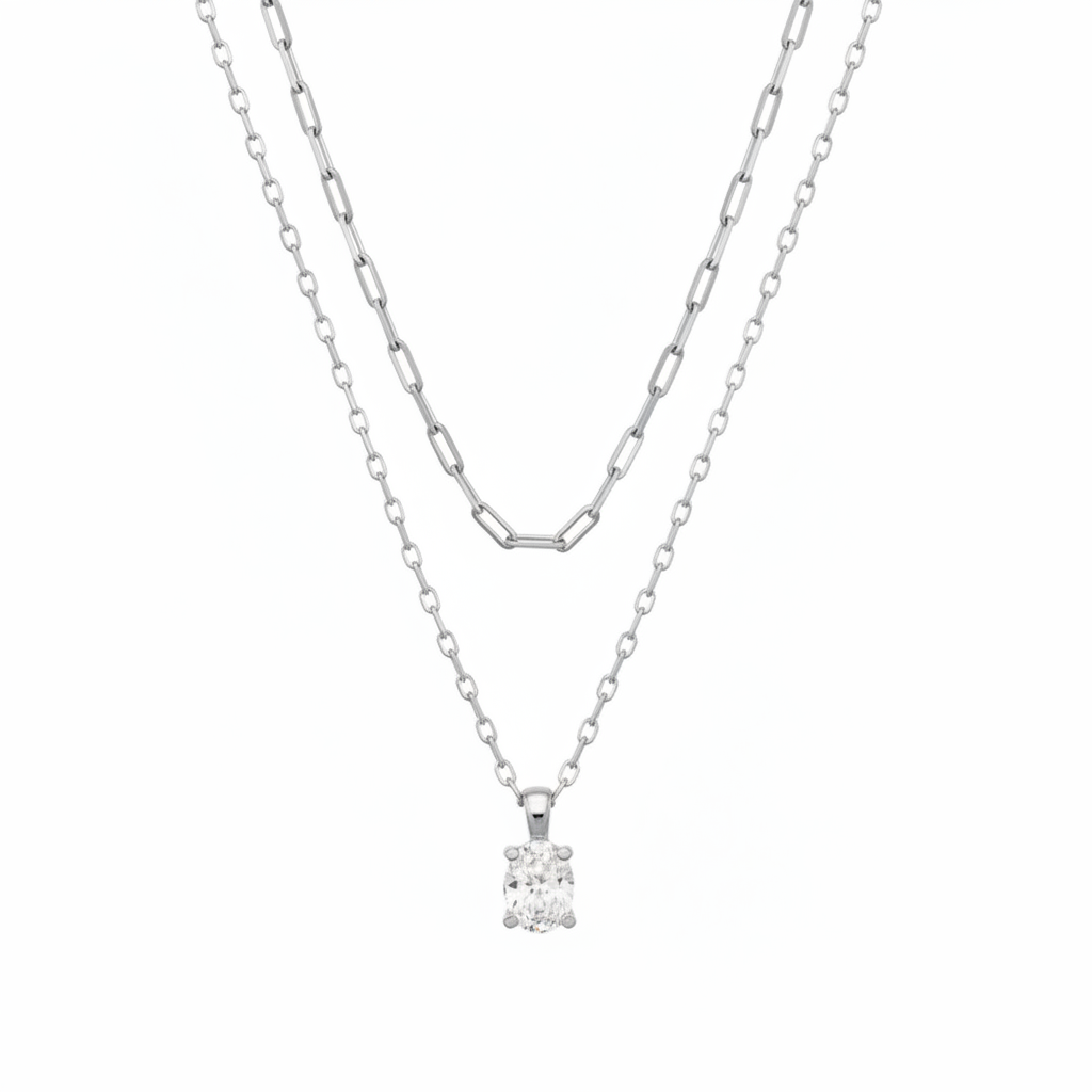 The Cailin Multi Strand Kendra Scott Necklace features two delicate silver strands: one with elongated oval links, the other a simple chain with a round-cut crystal pendant. Available in standard necklace lengths.