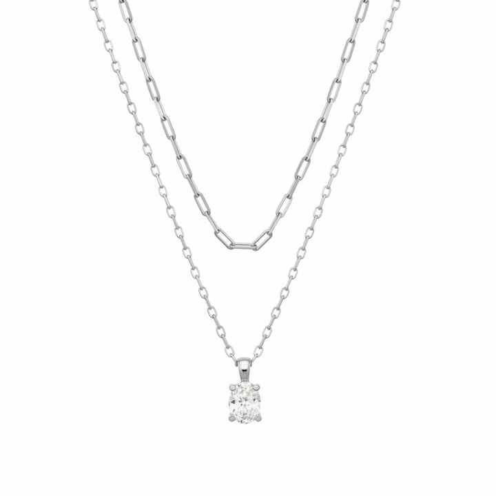 The Cailin Multi Strand Kendra Scott Necklace features two delicate silver strands: one with elongated oval links, the other a simple chain with a round-cut crystal pendant. Available in standard necklace lengths.