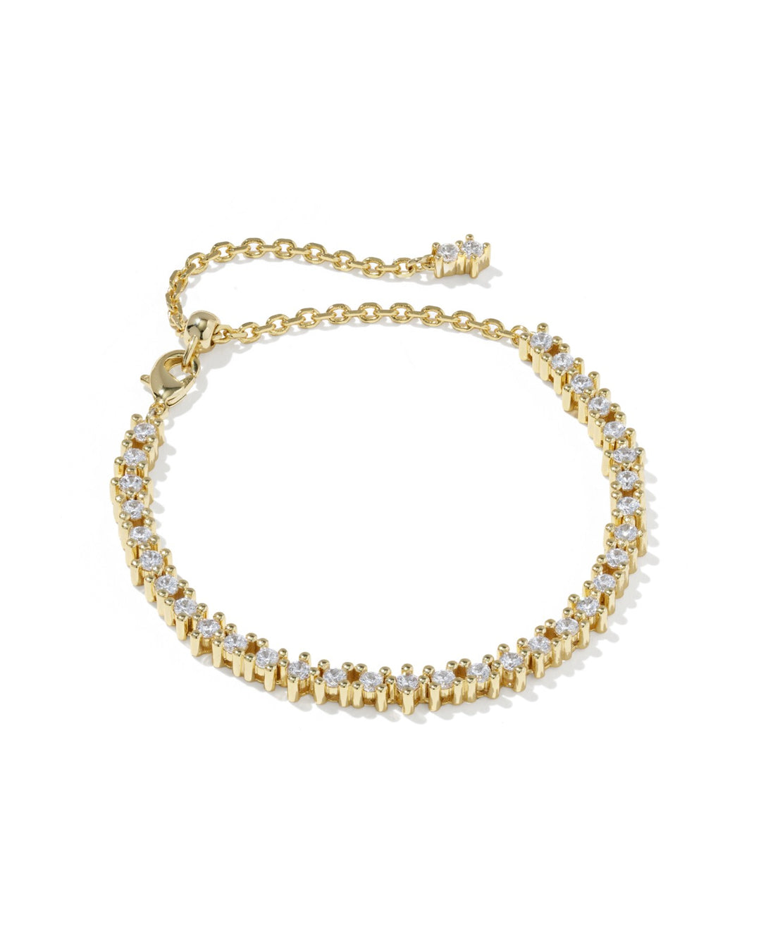 The Fate Tennis Gold White CZ Bracelet has clear round cubic zirconia stones on a gold band, with an adjustable chain and clasp. Available sizes: S, M, L.