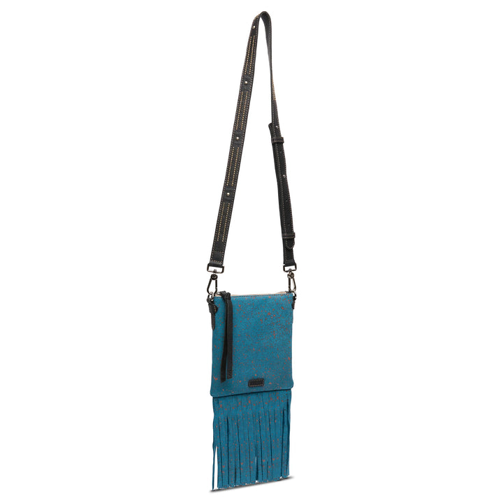 Teal crossbody bag with orange speckles, fringe, and black studded strap. Explorer Mini, Nilo. Sizes: small, medium.