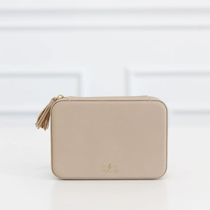 Beige rectangular Hollis zippered pouch with tassel, gold logo, and “HOLIS” on front. Jewelry organizer; available in multiple sizes.