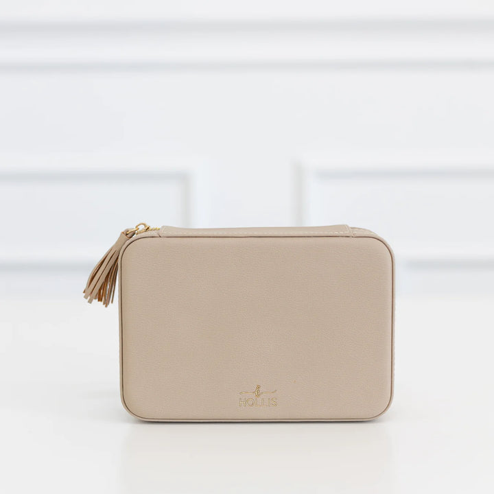 Beige rectangular Hollis zippered pouch with tassel, gold logo, and “HOLIS” on front. Jewelry organizer; available in multiple sizes.