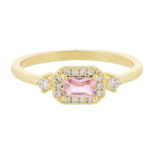 This product is an exquisite 18K Gold Plated ring, spotlighting a central pink rectangular gemstone. It's encased by mini crystal outlines and accented side crystals giving it an elegant touch. The ring features extra small diamonds set intricately into the band, adding more sparkle and glamour to the design. Available in various sizes for perfect fit.