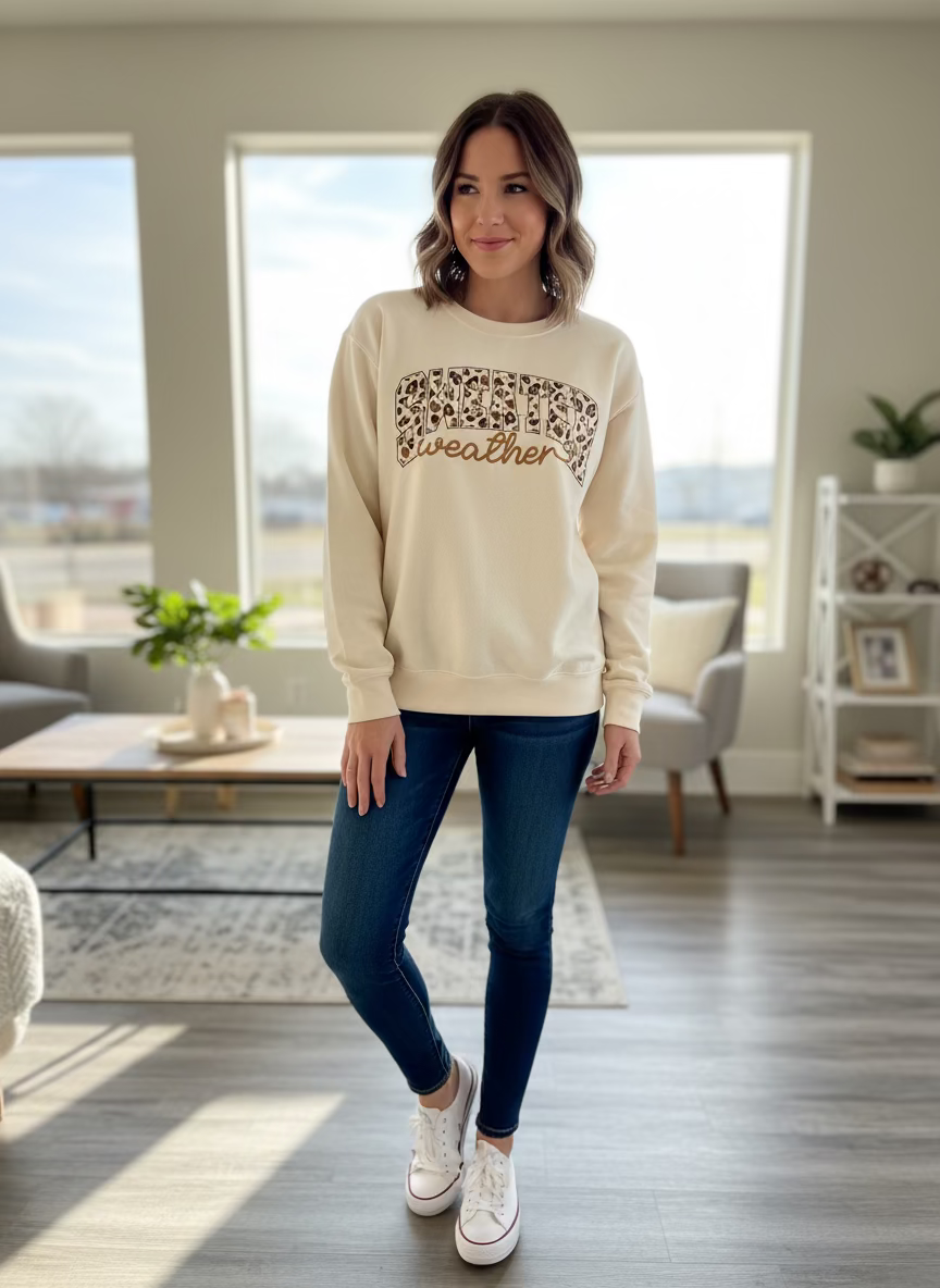 Cream sweatshirt with leopard-print “sweater weather” graphic. Available in multiple sizes.