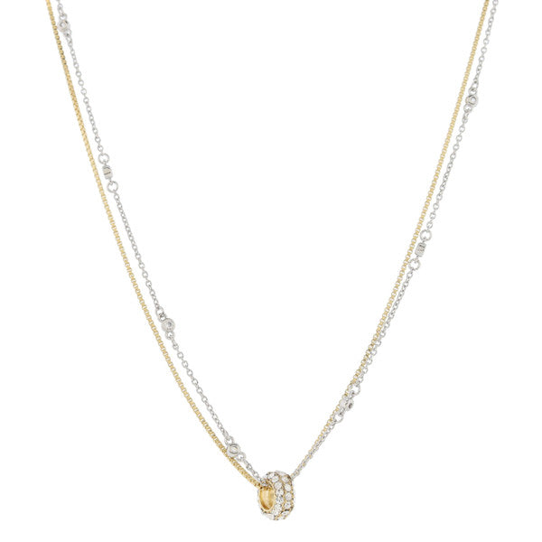 This product is an elegant and high-quality necklace. It features a double-strand gold box chain combined with a silver crystal station chain. The necklace includes a .35" pendant that is beautifully adorned with several diamonds and one larger gemstone. The focal point of the necklace is the gold pave ring that brings together every element of this stylish piece.