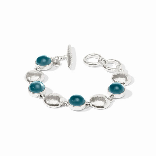 Silver bracelet with hammered discs, teal-blue iridescent stones, toggle clasp. Available sizes: S, M, L.