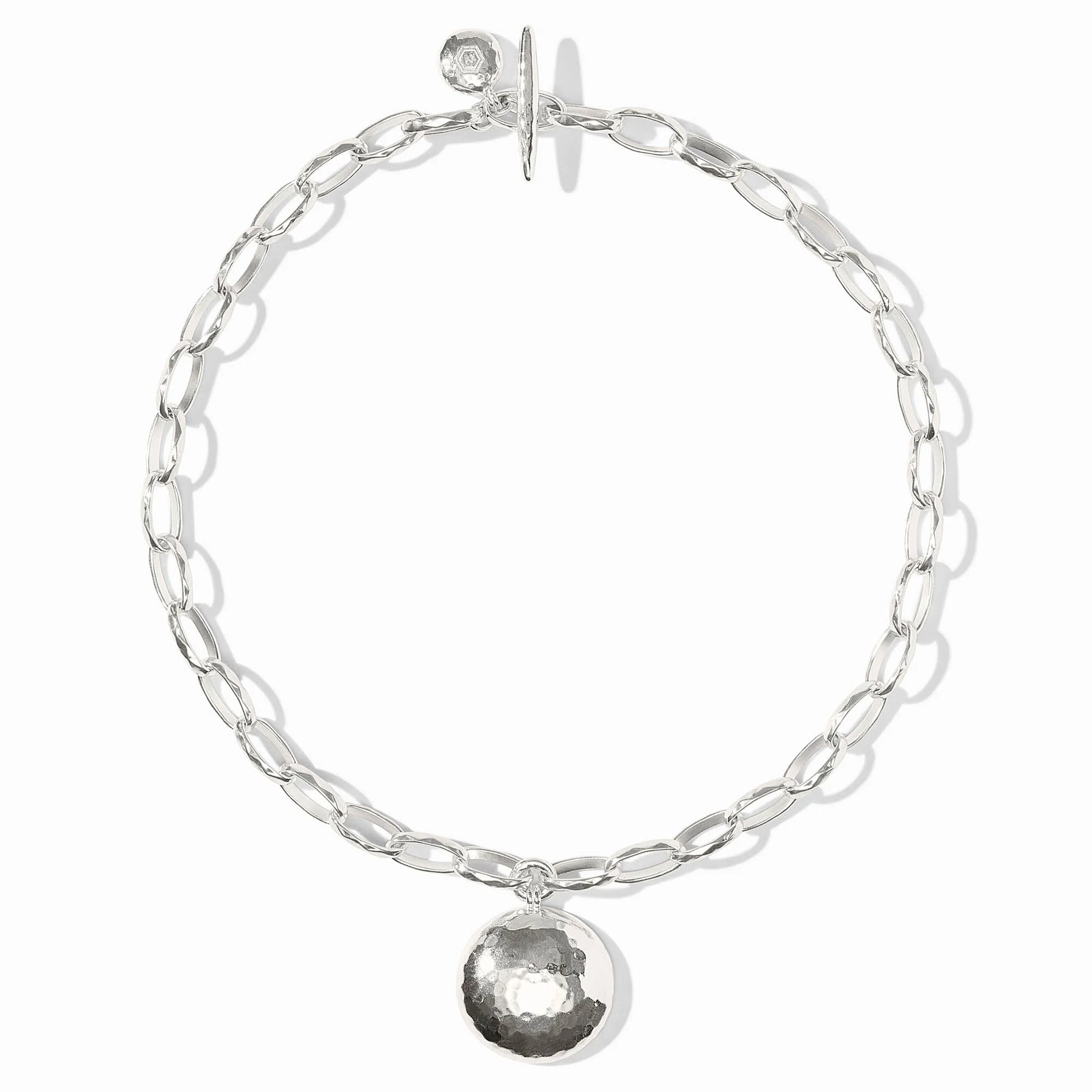 The Solara Necklace Silver: elongated oval chain, hammered starburst medallion, toggle clasp. Available in 16", 18", 20".