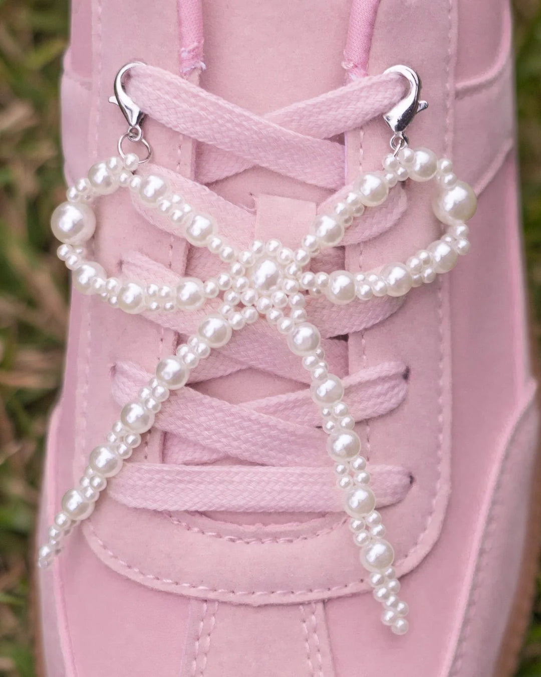 White faux pearl bow sneaker clip-on accessory. Available in small, medium, and large sizes. Clips onto sneaker laces.