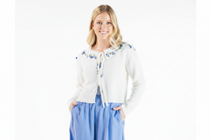 Lightweight white flowered cardigan; available in sizes XS-XL. Blue pants not included.
