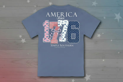 Blue tee with "AMERICA Since 1776" and patriotic icons on back; "Simply Southern Collection" below. Sizes S-XXL.