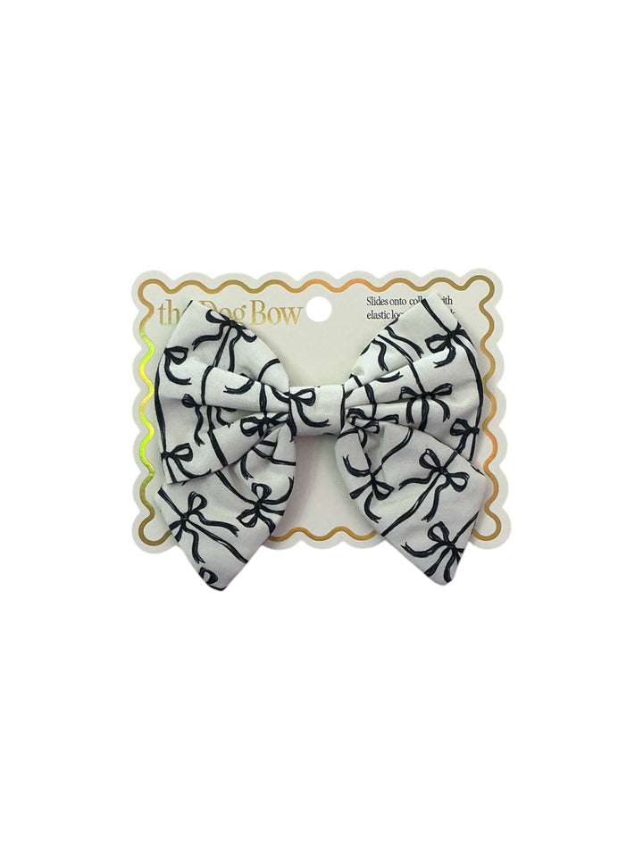 White fabric slide-on dog bow with black bows pattern, labeled "The Big Bow." Available in sizes S/M/L.