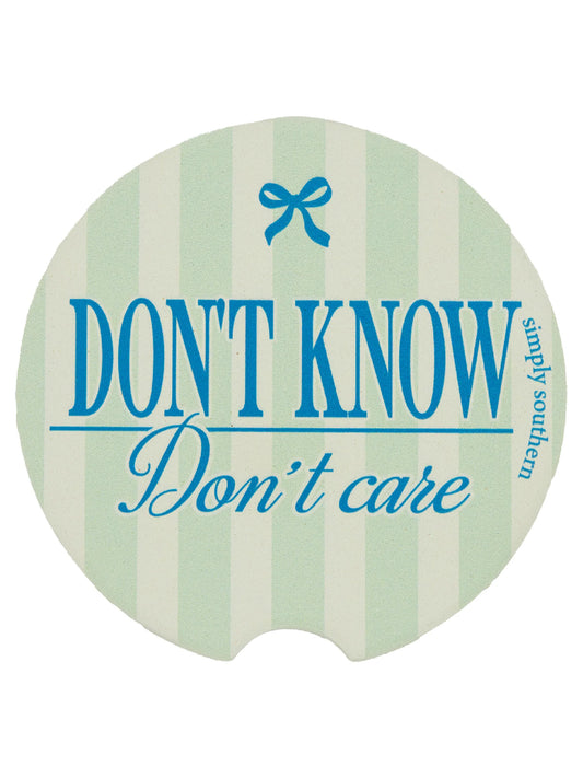 Oval water-absorbent car coaster, pale green/white stripes, blue "DON'T KNOW Don't care" text, one size fits most cup holders.