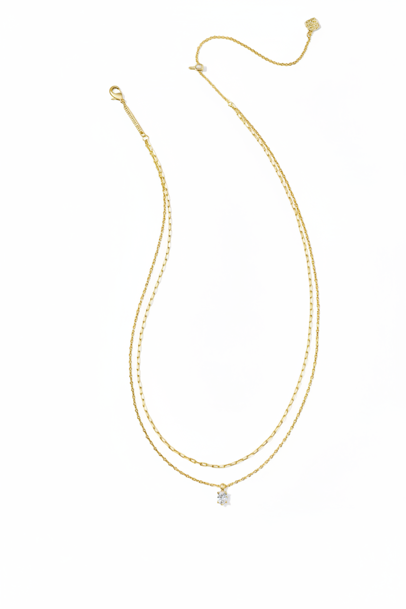 Gold double-layer necklace with delicate chains, small crystal pendant at the center, and adjustable clasp. Available in multiple sizes.