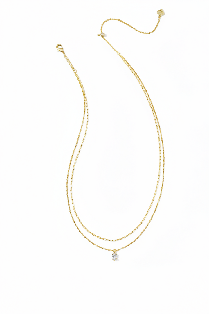 Gold double-layer necklace with delicate chains, small crystal pendant at the center, and adjustable clasp. Available in multiple sizes.