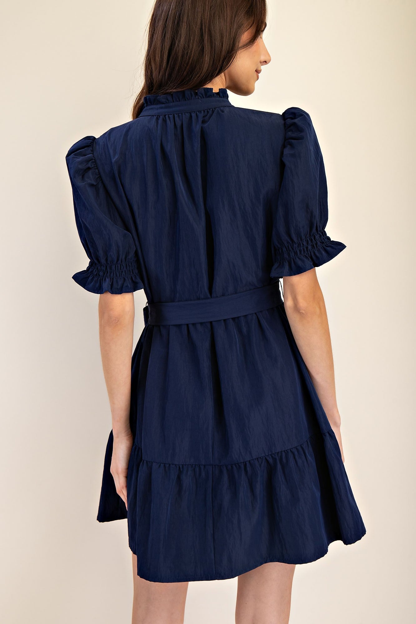 Mavis Navy Ruffle Neck Dress with puffed sleeves, belted waist, tiered skirt; available in sizes XS-XL.