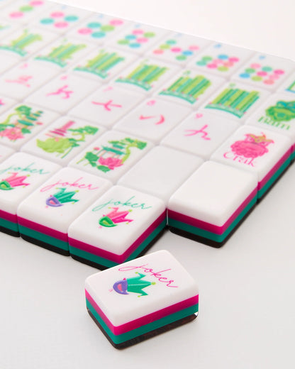 Glow Wild Mahjong Tiles with modern designs in pink, green, and blue accents; "joker" tile featured. Available in standard and travel sizes.
