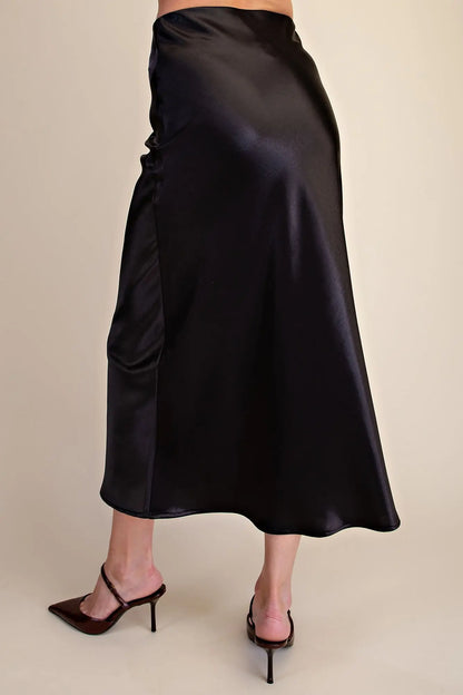 Glitter Midi Skirt: shiny black satin, elastic waist, classic midi length. Available in sizes XS–XL.