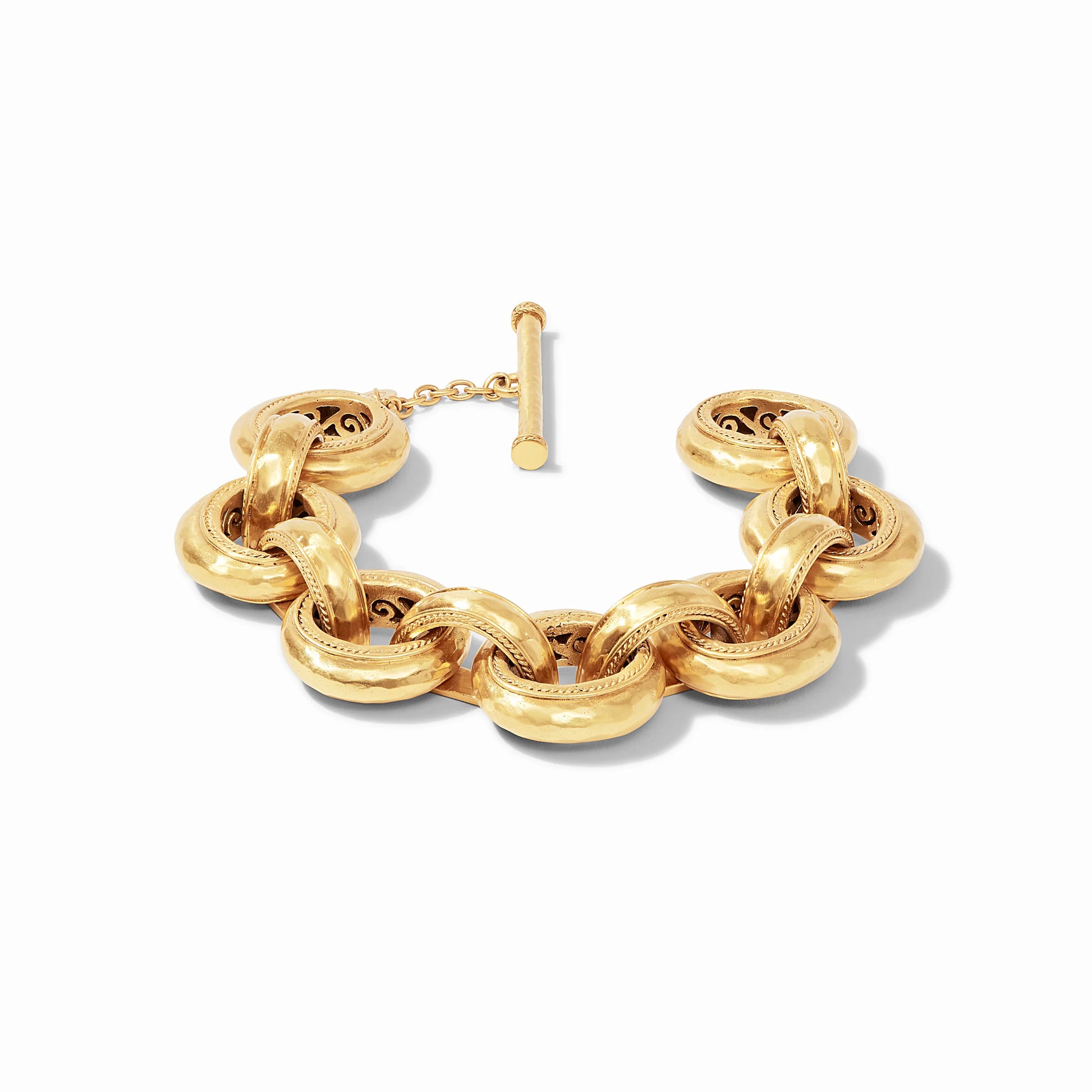 Chunky gold bracelet with large oval hammered links, toggle clasp, and intricate detailing inside each link; available in multiple sizes.