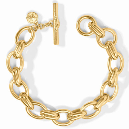 The Essex Link Bracelet by Julie Vos features large oval links with a chunky 24K gold-plated finish, secured with a toggle clasp and an engraved round charm. Available in multiple sizes.