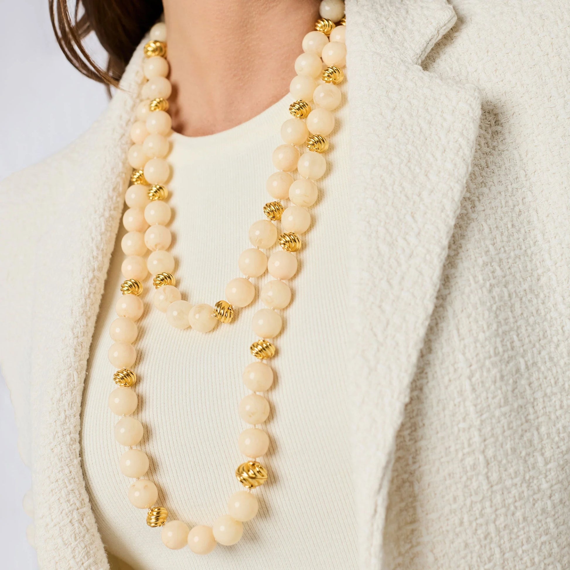 The Ravello 5-in-1 Ivory Necklace Gold by Julie Vos, featuring layered ivory beads and gold accents, is shown. Available in adjustable lengths.