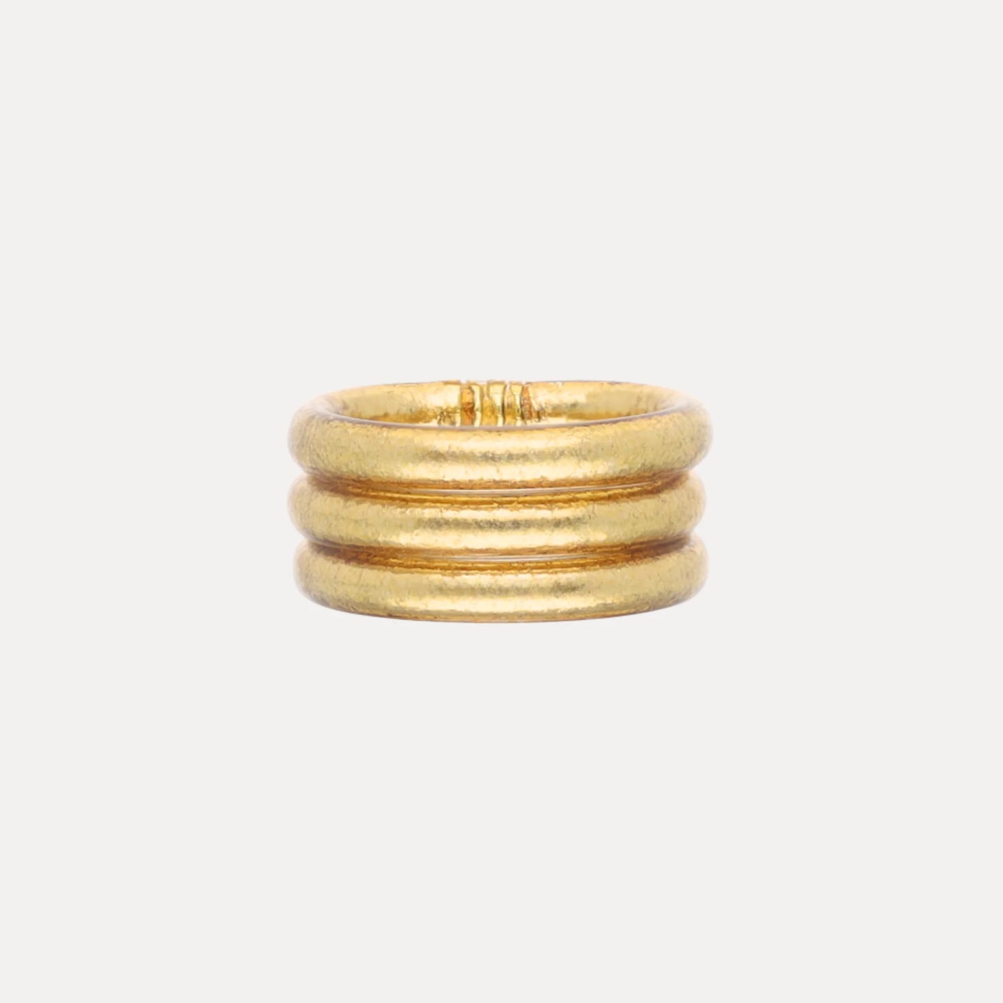 Set of three rounded gold bands, stacked together; waterproof and durable. Available in Size 7.