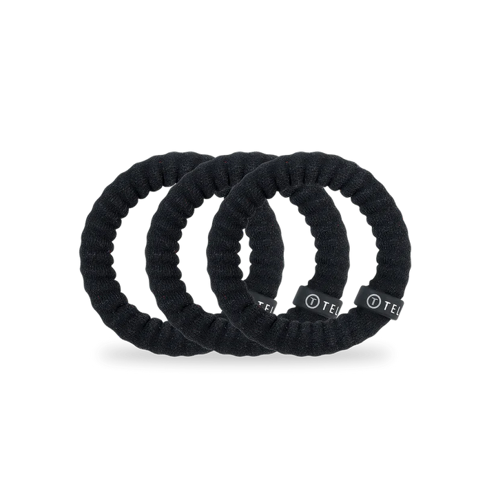 Three Jet Black TELETIES fabric hair ties, each with a black label. Available in small, medium, and large sizes.