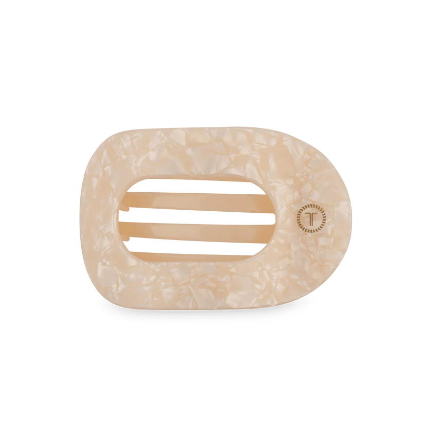 Cream-colored, marbled oval hair clip with three center slits and a "T" emblem; available in multiple sizes.