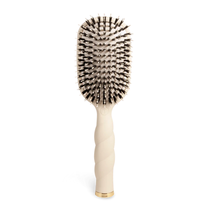 The Teleties Hair Brush is a beige detangler for thick hair with a twisted handle, gold accents, and anti-static dual-color bristles. Sizes: S/L.