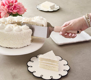 Cake Server Heart in use to serve a slice of white frosted cake; available in small, medium, and large sizes.